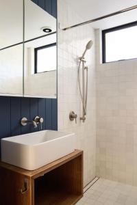 a bathroom with a white sink and a shower at Minden Retreat in Te Puna