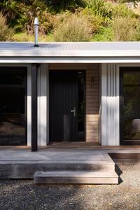a house with a wooden porch and a door at Minden Retreat in Te Puna