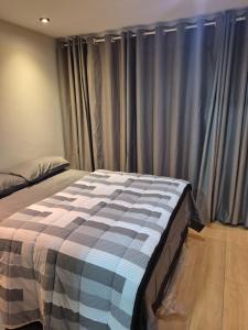 a bed in a bedroom with grey curtains at Um lar em Brasília, super aconchegante e com ar condicionado in Brasília +7 photos