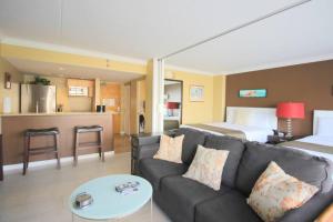 ein Wohnzimmer mit einer Couch und einem Bett in der Unterkunft Waikiki - Resort amenities, walk to the beach! in Honolulu