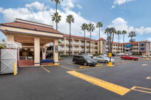 a parking lot with cars parked in front of a hotel at Quality Inn in Lomita