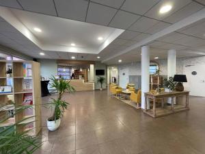 Un vestíbulo de oficina con sillas amarillas y una mesa. en Quality Suites Valenciennes, en Valenciennes