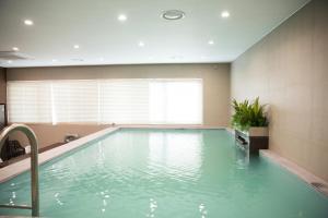 a swimming pool in a room with a large window at Hotel Mate Bundang in Seongnam
