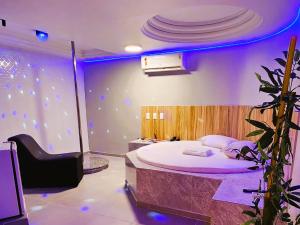 a bedroom with a bed in a room with purple lights at Fada Hotel - Motel Recife Adults Only in Recife