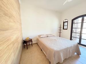 ベルチオガにあるCASA ACONCHEGANTE e PERTINHO DA PRAIAのベッドと窓のある白い寝室