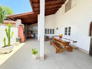 ベルチオガにあるCASA ACONCHEGANTE e PERTINHO DA PRAIAの木製テーブルとベンチ付きのパティオ