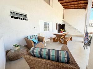 a living room with wicker furniture and a table at CASA ACONCHEGANTE e PERTINHO DA PRAIA in Bertioga
