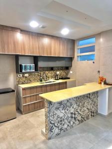 タリハにあるEl Molino Apartmentの木製のキャビネットとカウンタートップを備えたキッチン