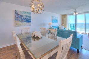 comedor y sala de estar con mesa de cristal en Crescent Shores South - 411, en Myrtle Beach
