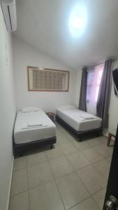 - 2 lits dans une pièce dans l'établissement Casa Pochó frente al Hospital Ángeles, à Villahermosa