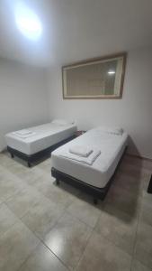 deux lits jumeaux dans une chambre avec un miroir dans l'établissement Casa Pochó frente al Hospital Ángeles, à Villahermosa 8 autres photos