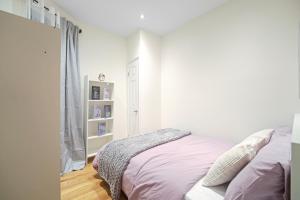 ein weißes Schlafzimmer mit einem Bett und einem Fenster in der Unterkunft 3BR Serene Suite Near Central Park in New York