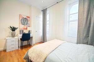 ein Schlafzimmer mit Bett, Schreibtisch und Fenster in der Unterkunft 3BR Serene Suite Near Central Park in New York