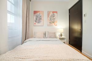 ein Schlafzimmer mit einem Bett und zwei Gemälden an der Wand in der Unterkunft 3BR Serene Suite Near Central Park in New York