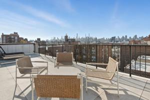 a balcony with chairs and tables and a city skyline at Elegant Studio Apartment in Steinway