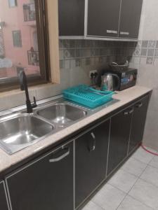 Una encimera de cocina con un fregadero y un fregadero. en Carlo Van Apartment, en Accra 15 fotos más