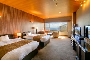 a hotel room with two beds and a flat screen tv at Sundance Resort Izu Kogen in Ito