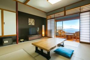 a living room with a table and a television at Sundance Resort Izu Kogen in Ito