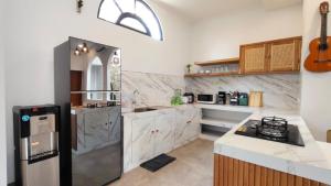 a kitchen with a refrigerator and a counter top at Candra Villa Kedungu in Tanah Lot