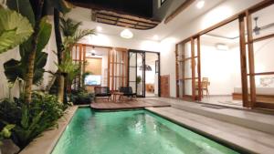 an indoor pool in a house with plants at Candra Villa Kedungu in Tanah Lot