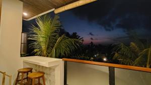 a room with two chairs and a wall with a mural at Candra Villa Kedungu in Tanah Lot