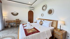 a bedroom with a bed and a desk in a room at Candra Villa Kedungu in Tanah Lot