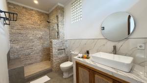 a bathroom with a sink and a toilet and a mirror at Candra Villa Kedungu in Tanah Lot +12 photos