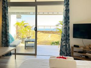 a living room with a view of the ocean at Air-conditioned sea access studio, fiber optic, parking in Punaauia