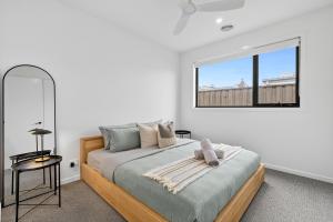 Una cama o camas en una habitación de Duneview Luxe Ocean Grove Sleeps 8, 4 bedroom, aircon,heating throughout, Designer quality, Perfect wedding stay, family friendly, Beach, Park, Shops