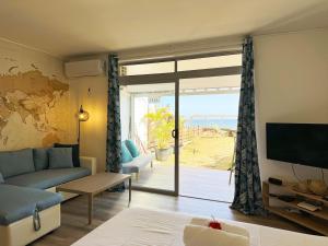 a living room with a couch and a sliding glass door at Air-conditioned sea access studio, fiber optic, parking in Punaauia