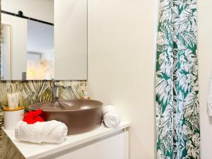 a bathroom with a sink and a mirror at Air-conditioned sea access studio, fiber optic, parking in Punaauia +55 photos