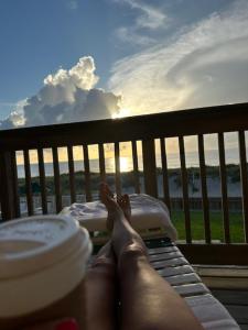a person laying on a balcony with their feet on a table at Beachfront Aparthotel in Deerfield Beach with Panoramic Views of the Ocean! in Deerfield Beach +5 photos