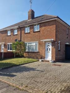 une maison en briques avec une porte blanche et une allée dans l'établissement Cavan Havan, à Broadstone