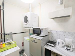 eine Küche mit einer Mikrowelle auf dem Kühlschrank in der Unterkunft Lavilla aveneu / Vacation STAY 73439 in Okinawa + 22 Fotos