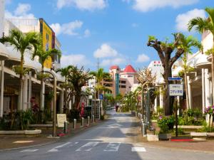 eine Straße in einer Stadt mit Palmen und Gebäuden in der Unterkunft Lavilla aveneu / Vacation STAY 73439 in Okinawa