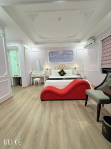 a bedroom with a red bed and a chair at One Villa Hotel 6 in Long Biên