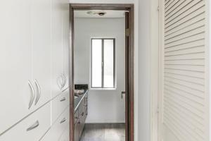 een deur die leidt naar een gang met witte kasten en een raam bij Lakeside Comfort condo in Lake Arrowhead