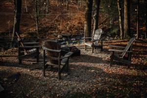 a group of park benches sitting in the woods at Le 88 Howard - Spa Sauna River & Cute Bridge in Mansonville