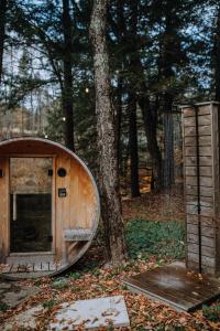 a small wooden boat sitting next to a tree at Le 88 Howard - Spa Sauna River & Cute Bridge in Mansonville