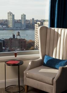 uma cadeira e uma mesa num quarto com uma janela em Arthouse Hotel em Nova York