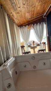 a bath tub in a room with a table at Cabana com banheira de Hidro e vista para o mar, privativa e tranquila localização excelente in Florianópolis