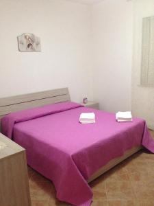 Lido SignorinoにあるVilla del Soleのベッドルーム1室(紫色のベッド1台、タオル2枚付)