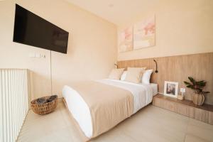 ein Schlafzimmer mit einem Bett und einem Flachbildfernseher in der Unterkunft Villa VIDA - Stylish 1-Bedroom Villa with Private Pool in Bingin Beach