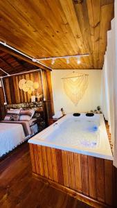 a large bath tub in a room with a bed at Cabana com banheira de Hidro e vista para o mar, privativa e tranquila localização excelente in Florianópolis