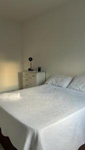 Una gran cama blanca con una cómoda en un dormitorio. en Quarto Moderno e aconchegante para hospedagem, en Foz do Iguaçu