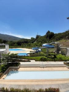 Πισίνα στο ή κοντά στο Agradable y confortable apto vacacional en Santa Fé de Antioquia-Colombia dentro de condominio con piscina, tobogán, zonas recreativas, jardines y espectacular vista