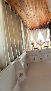 a bath tub in a room with a window at Cabana com banheira de Hidro e vista para o mar, privativa e tranquila localização excelente in Florianópolis