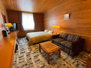 a bedroom with a bed and a couch in a room at Kibi Kogen Resort Hotel in Kaga