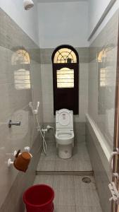 a bathroom with a toilet and a window at Singaravelu rooms in kāraikāl