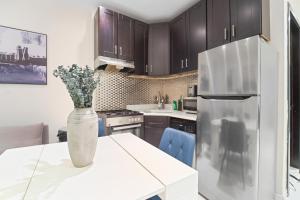 eine Küche mit einem weißen Tisch und einem Kühlschrank in der Unterkunft 3BR Serene Suite Near Central Park in New York